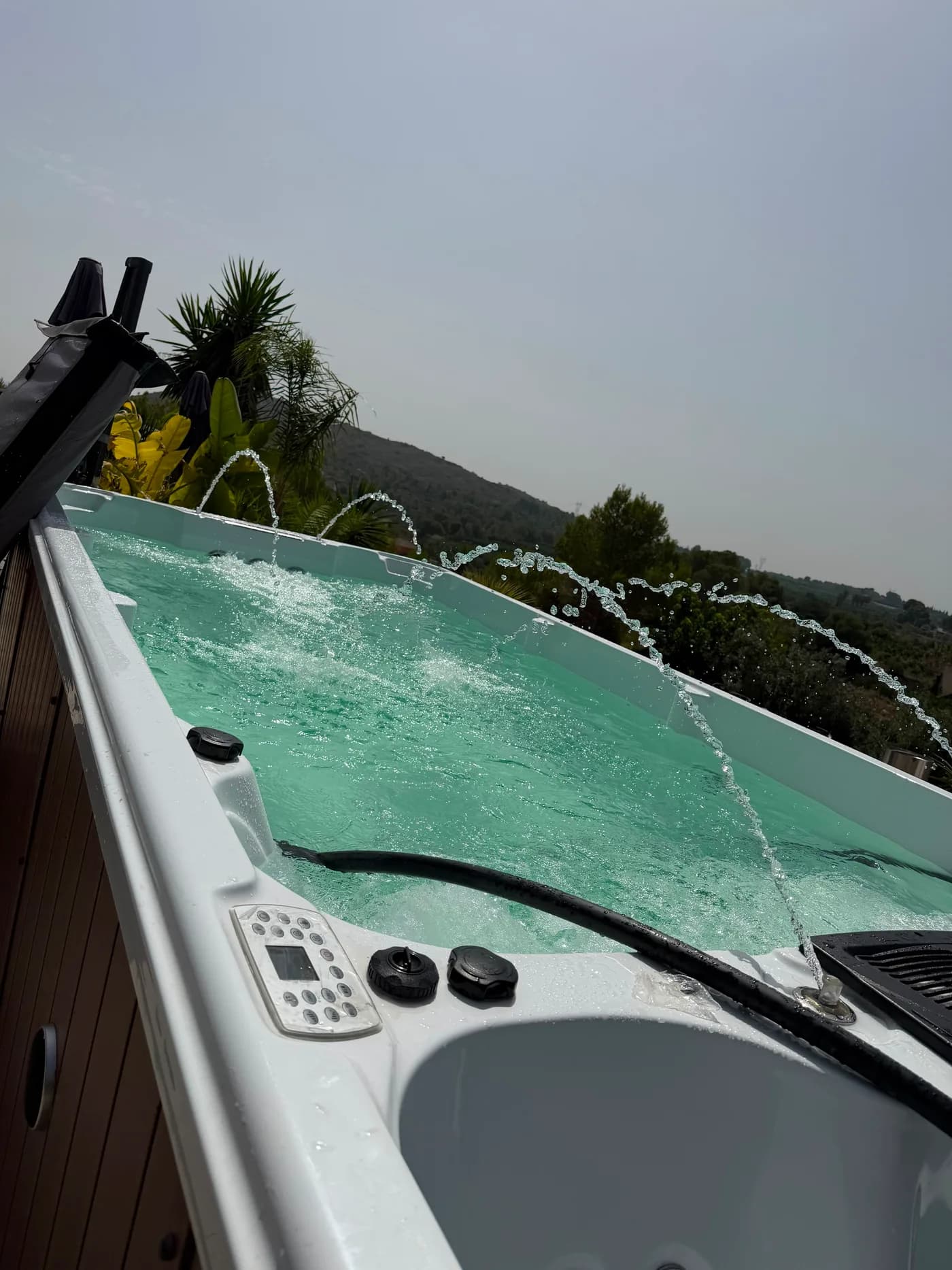 Jacuzzi exterior con los chorros en marcha y la montaña al fondo