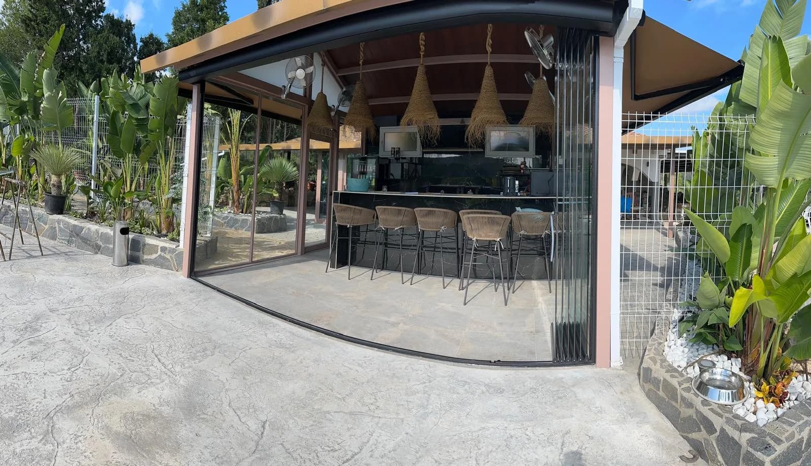 Zona gourmet exterior con barra de piedra y taburetes