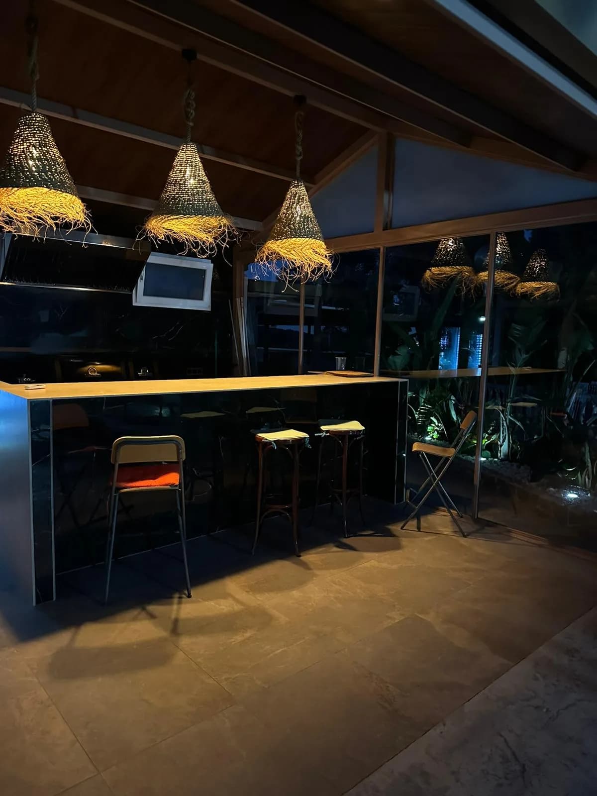 La zona gourmet iluminada de noche, con la barra encendida